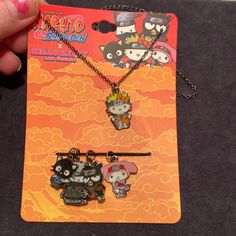 two necklaces with cartoon characters on them are being held up by someone's hand