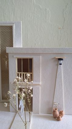 there is a small doll house with flowers in it