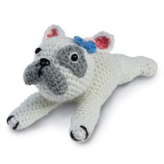 a crocheted dog laying on its side with it's eyes wide open