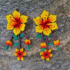 These beaded earrings come from many different families of the Wixarika(Huichol) Nation who reside in TaTeki village of San Andres, Jalisco Mexico. These pieces were purchased on pilgrimage to Wixrikuta from families who do not have the opportunity to leave and sell their art outside of the villages. Purchasing this artwork helps the locals buy food, clothing, school supplies for their children, and also candles for their prayers and offerings. For many of these artisans, this work is their only Traditional Handmade Flower Earrings, Traditional Handmade Flower Earrings For Festivals, Handmade Traditional Flower Earrings For Festivals, Artisan Multicolor Handmade Flower Earrings, Handmade Artisan Multicolor Flower Earrings, Artisan Handmade Multicolor Flower Earrings, Traditional Dangle Flower Earrings For Festivals, Traditional Yellow Handwoven Beaded Earrings, Traditional Colorful Beaded Flower Earrings For Festivals