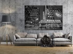 a living room with a couch, lamp and large poster on the wall above it