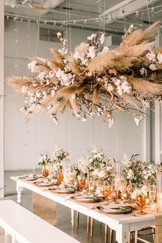 the table is set with flowers, candles and place settings for an elegant dinner party