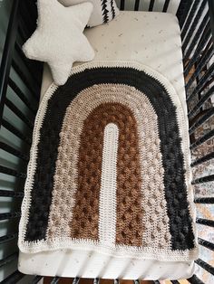 a crocheted blanket on top of a bed next to a pillow and star