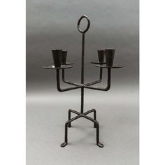 a metal candelabra with two candles on it's sides and one candle holder in the middle