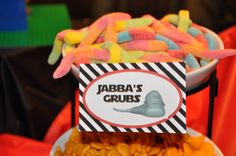 there is a bowl full of gummy worms on top of a table with a sign that says jabra's grubs