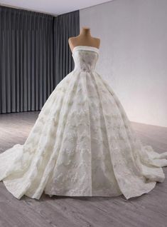 a white wedding dress on display in a room