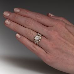 a woman's hand with a ring on it and a diamond in the middle