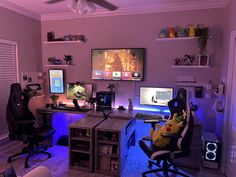 a living room filled with furniture and two computer monitors