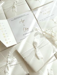 the wedding stationery is laid out on top of each other with ribbons and bows