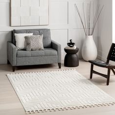 a living room with a gray couch and white rug in front of a painting on the wall