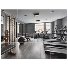 an exercise room with mirrors and treadmills