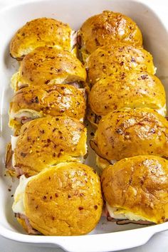 a casserole dish filled with rolls covered in cheese and meats, ready to be eaten