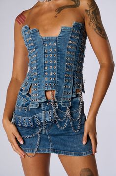 In the wise words of Avril Lavigne… “I’m a rocker chick. I like to rock out.” The AKIRA Label Just Wanna Rock Denim Tube Top is a corset-inspired crop top crafted from super stretchy, patchworked denim strips in a medium blue wash. It features an intentionally jagged hem and neckline, a contrast lace-up back closure, metallic silver grommet detailing throughout, and decorative, detachable chain link accents in metallic silver near the hemline. Pair it with the coordinating Just Wanna Rock Denim Mini Skirt for a stage-worthy ensemble.  - 68% Cotton, 27% Polyester, 3% Rayon, 2% Spandex- Super Stretchy- Imported (all measurements approximate from size small) - 14” Chest to Longest Hem- 9” Chest to Shortest Hem - 7” Dangling Chain Attachments - Model is 5’7”Product ID: 394037 Fitted Distressed Blue Denim Top, Medium Wash Denim Tube Top, Fitted Cropped Denim Tube Top, Denim Boobtube Top, Sleeveless Denim Blue Corset, Denim Tube Top, Rocker Chick, Top Crafts, Denim Mini Skirt