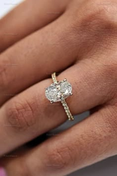 a woman's hand with a diamond ring on top of her finger and an engagement band