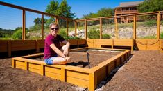 a man sitting on top of a wooden box in the middle of some dirt and grass