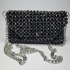 The Black Vision Bag is a statement piece crafted from solid glossy beads in an irregular shape, giving it a striking and unique appearance. Made with meticulous craftsmanship, this 100% handmade bag features a 0.6 mm string thickness and is lined with distinctive fabric. The glossy black beads catch the light beautifully, making this bag a bold and elegant choice for any occasion. Black Beaded Pouch Clutch, Luxury Black Beaded Evening Bag, Gift Black Beaded Shoulder Bag, Black Beaded Rectangular Clutch, Black Beaded Evening Bag As Gift, Handmade Black Clutch Evening Bag, Luxury Handmade Black Evening Bag, Black Beaded Evening Bag For Gift, Handmade Black Party Bag