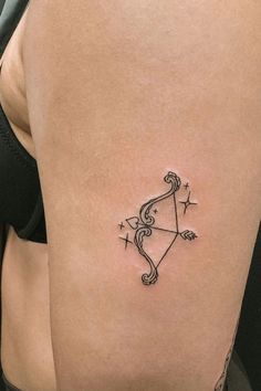 an arrow tattoo on the back of a woman's stomach is shown in black ink