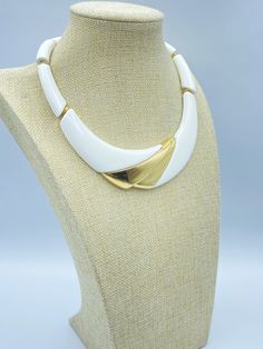 A Vintage Napier White and Gold Necklace. This is the 1988 Napier is Brainier ad necklace in white hard resin with gold tone accents. The choker is 17 inches long. Along with the gold tone accents on the pendant there curved tube beads and gold tone flat spacer beads. This Napier choker has a spring ring clasp with a metal hang tag signed Napier©. The length of the curved pendant is 6 (inside) and 8 (outside) inches. The width of the pendant is 1 3/8 inches at its widest. This Napier white and gold pendant choker has a substantial weight of 2.96 ounces. Minor surface scratching is visible under a loupe but not to the unaided eye.  This piece is in excellent condition. Add this 80s Napier necklace to your Napier jewelry collection! Please see the photos and don't hesitate to contact me to a Retro White Jewelry For Anniversary, Vintage White Necklace For Anniversary, White Retro Jewelry For Anniversary, Napier Jewelry, Pendant Choker, Choker Necklaces, Tube Beads, Spacer Beads, Spring Rings