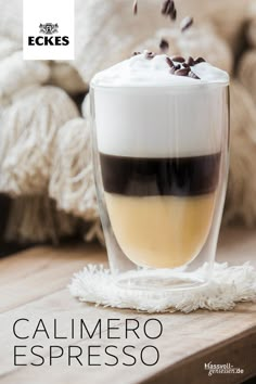 a cup filled with liquid sitting on top of a wooden table