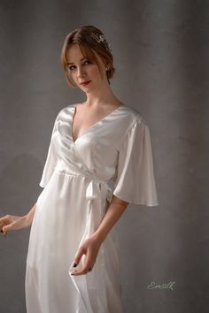 This luxury exclusive design is perfect as a simple wedding outfit. 100 % designed and handmade by Emsilk. I am pleased to offer your garments made to measure at no extra cost. All of my designs can be made in any colors that you see in my shop. * Detail: - Wrapped Deep V neckline front and back- Large Ruffle sleeves- Silk belt straps on waist- Ruffle wrapped pencil bottom- Invisible side zipper- Floor length- Fully lined-Best quality silk, 100 % pure 19mm Mulberry Silk in ivory white which is m Feminine Wedding Dress With Satin Finish, Satin Finish V-neck Dress For Wedding Night, V-neck Dresses With Satin Finish For Wedding Night, Chic Silk Wedding Dress With Satin Finish, Chic Silk Dress With Satin Finish For Wedding, Chic V-neck Silk Dress For Wedding, Wedding Night V-neck Dress With Satin Finish, Elegant Short Sleeve Silk Dress, Short Sleeve Satin Wedding Gown