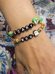 "The Scary Clay Sugar Skull Beaded Word Bracelet has a spooky fun vibe and makes a cute accessory to any autumn outfit. 🍂  Bracelets are all HANDMADE with love and care by myself, Candice Marie, and they are always limited edition and one-of-a-kind. ❤️ 4mm glass seed beads, rhinestone crystal bicone beads, and heishi clay beads were used to make this bracelet. The word \"SCARY\" is spelled out on black round letter beads in white writing. A polymer clay sugar skull head charm adorns the band of Handmade Halloween Festival Bracelets, Handmade Halloween Festival Bracelet, Handmade Bracelets For Halloween Party, Handmade Bohemian Bracelets For Halloween, Bohemian Handmade Bracelets For Halloween, Halloween Party Beaded Bracelets, Fun Black Beaded Bracelets With Round Beads, Black Beaded Bracelets For Party In Novelty Style, Halloween Novelty Beaded Bracelets With Round Beads