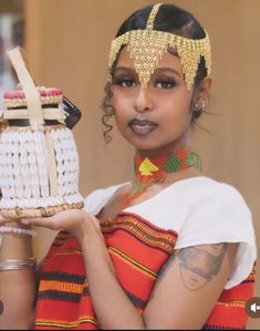 a woman in an ethnic dress holding a basket with a ship on it's side