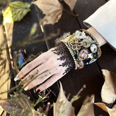 Indulge in the allure of our Vintage-Inspired Cowhide Leather Cuff Bracelet. Crafted on an 8 cm wide cowhide leather base, this unique piece features rustic wooden buttons, Gemstone Cross earthy tones embellished with high quality agate beads, rhinestones rustic wood buttons, vintage lace,  Swarovski stones, and a vibrant brown lace border for a touch of exotic elegance. This cuff is a testament to meticulous craftsmanship, adding a vintage flair to your style.  Embrace the joy of gifting or tre Vintage Hand Wrapped Bracelets For Gift, Vintage Hand Wrapped Wrap Bracelet For Gift, Vintage Hand Wrapped Wrap Bracelet Gift, Handmade Adjustable Bracelet For Accessorizing, Adjustable Handmade Bracelets, Unique Wrap Bangle Bracelet As Gift, Handmade Steampunk Bracelets As Gift, Handmade Steampunk Bracelets For Gift, Steampunk Style Bracelet Jewelry Gift