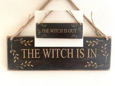 a wooden sign hanging on the wall that says, the witch is in with it