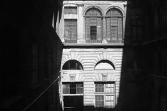 an old building with arched windows and shutters on the outside is shown in black and white