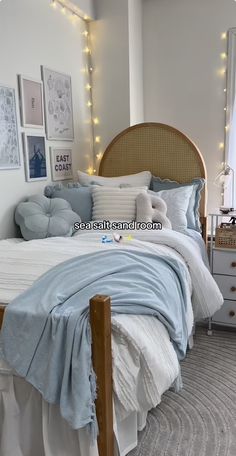 a bed with blue and white comforters in a bedroom next to pictures on the wall