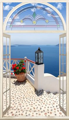 an open window with a potted plant on the balcony overlooking the ocean and blue sky