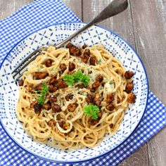 a blue and white plate topped with pasta and meat