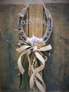 a wreath hanging on the side of a wooden door that says welcome with an arrow