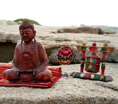 a buddha statue sitting on top of a red rug next to other decorations and items