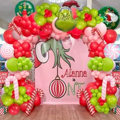 the balloon arch is decorated with red, green and white balloons that spell out it's name