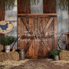 an old barn with hay bales and wooden doors