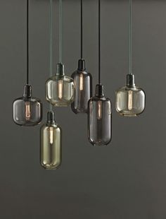 an assortment of glass pendant lights hanging from a ceiling in a kitchen or dining room