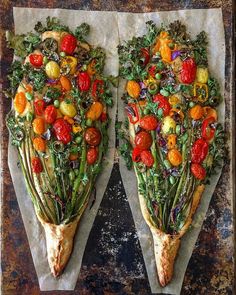 two slices of pizza topped with veggies on top of parchment paper next to each other