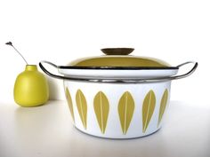 a white and yellow casserole sitting next to a green pear on a table