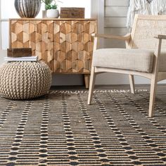 a living room area with a chair, rug and sideboard