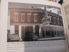 an open book showing the front and side of a restaurant with cars parked in front