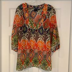 Women's Tribal Brand Boho Tunic Top ~ V-Neckline ~ Semi Sheer ~ 3/4 Length Sleeves With Elastic Trim ~ Vivid Multi-Color Print ~ Size 8 (Seems To Run Larger So Please Refer To Measurements Provided) ~ Excellent Gentle Pre-Owned Condition ~ Likely Never Worn ~ From A Smoke-Free Home Approximate Measurements: Length ~ 27" Bust ~ 43" Summer Orange V-neck Blouse, Casual Orange Tops With 3/4 Sleeves, Casual Orange Top With 3/4 Sleeves, Casual Orange 3/4 Sleeve Top, Orange Vibrant Print Blouse For Beach, Orange Vibrant Print Beach Blouse, Orange Printed V-neck Blouse, Orange Blouse With Vibrant Print For Spring, Spring Orange Tops With Colorful Pattern