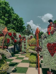 a garden with lots of fake flowers and plants on it's sides, in the shape of hearts