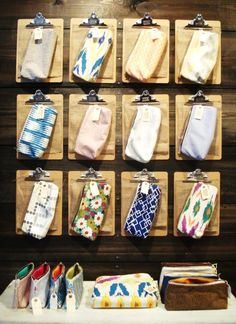 a bunch of ties are hanging up on a wall next to some wallets and purses