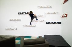 a young boy climbing up the side of a wall with his feet in the air