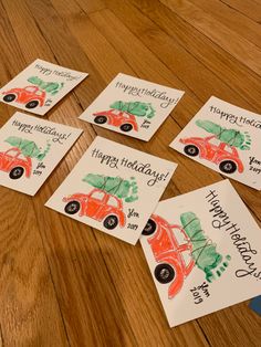 four cards with cars and trees on them sitting on a wooden floor next to each other