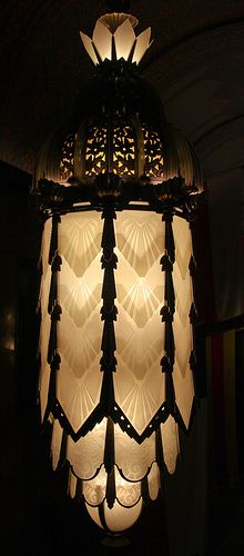 a light that is hanging from the ceiling in a room with dark walls and flooring