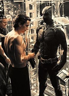 the dark knight rises movie scene with batman and catwoman talking to two men in costume