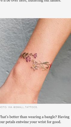 a small wrist tattoo with flowers on it