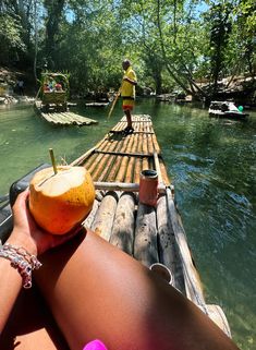 a person is sitting on a raft with an orange in their hand while another person walks across the water